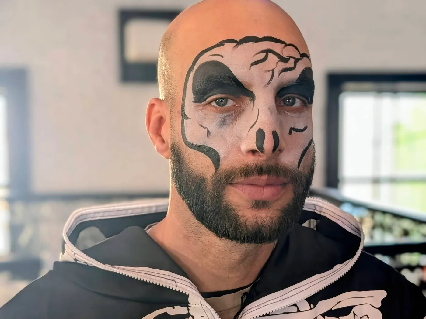 An adult wearing a skeleton face-painting design